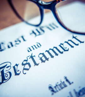An image of glasses resting on a will, which is often a central document to the final distribution of estate assets.