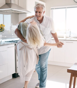 Two parents dancing in their kitchen, carefree after their parents answered, How do you take care of elderly parents’ finances?