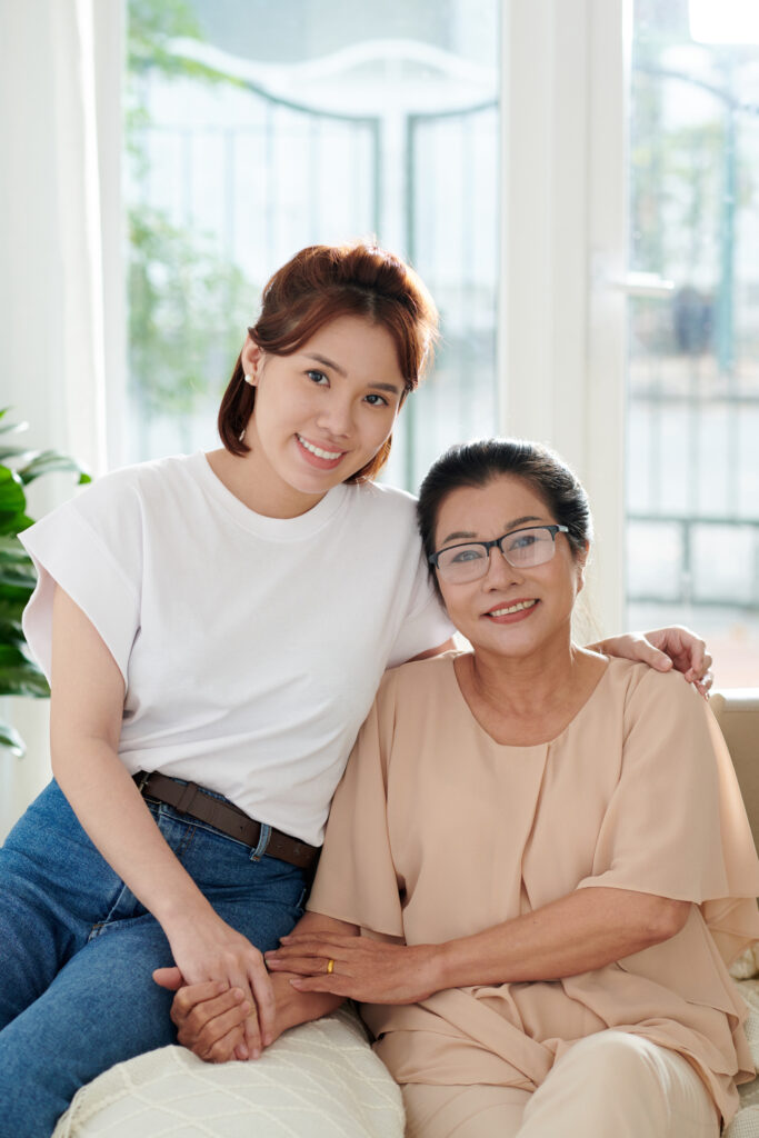 A daughter smiling with her mother who can enjoy retirement thanks to daily money management services for seniors. 
