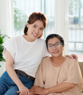A daughter smiling with her mother who can enjoy retirement thanks to daily money management services for seniors.