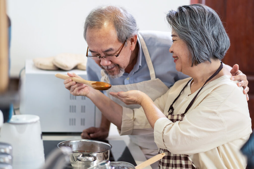 A man and woman enjoying retirement and tasting soup after their child learned the benefits of setting up a trust in California for seniors.