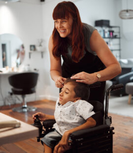 A person smiling and helping their special needs loved one do their hair after looking into the responsibilities of a trustee of a special needs trust to find the best person for the job!