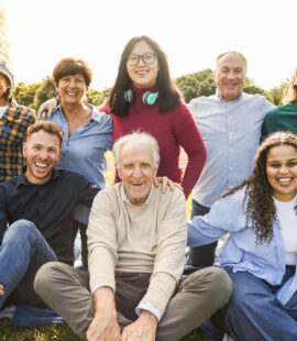 A happy senior with his whole family, smiling because he thoroughly prepared with wealth transfer strategies by utilizing a trust and professional fiduciary.